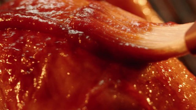 Chicken breast brushed with barbecue sauce in extreme close up