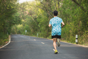 Young man running in the nature. Healthy lifestyle and sport concepts.  Runner training in a urban area.The man with runner on the street be running for exercise.