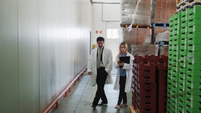 WS&nbsp;DS&nbsp;TS MS People in lab coats walking in warehouse in food processing plant