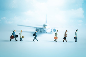 Miniature people, group of travelers standing in front of plane. Air travel and tourism, aviation industry crisis concept.