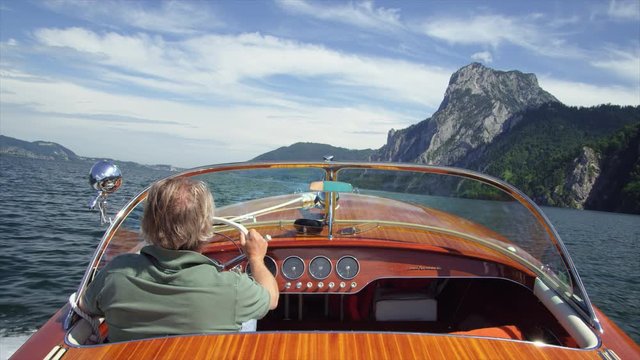 MS&nbsp;POV&nbsp;Man riding motorboat in&nbsp;Traunsee&nbsp;Lake with Traunstein mountain visible