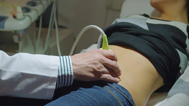 CU Hand of doctor performing ultrasound examination on female patient