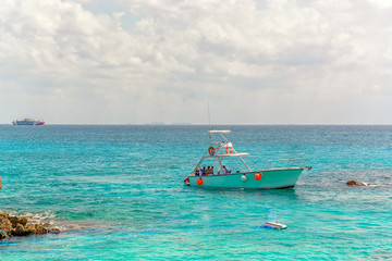 Fototapeta na wymiar Small white ship with tourists in the azure sea.