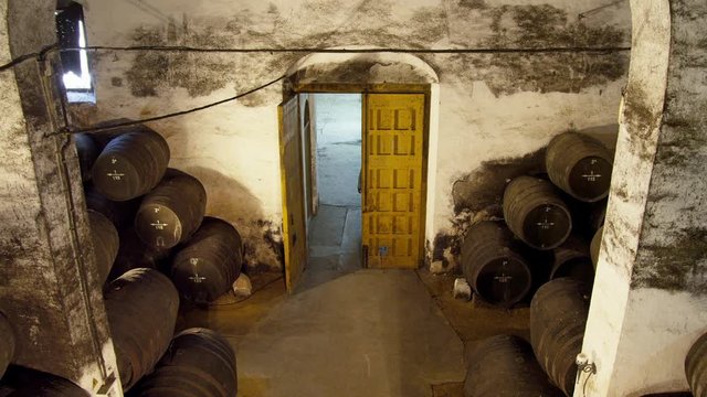 HA WS Man entering wine cellar with wine casks