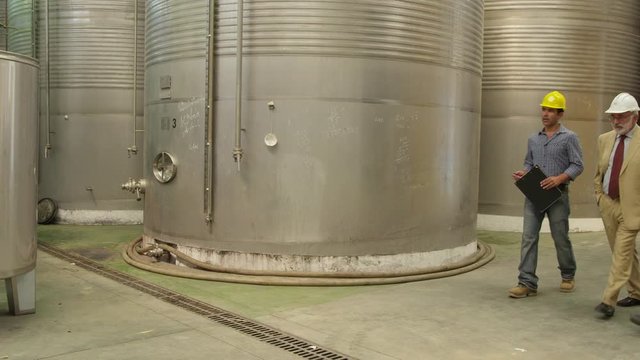 WS TS Worker, Manager And Lab Technician Walking In Front Of Storage Tanks