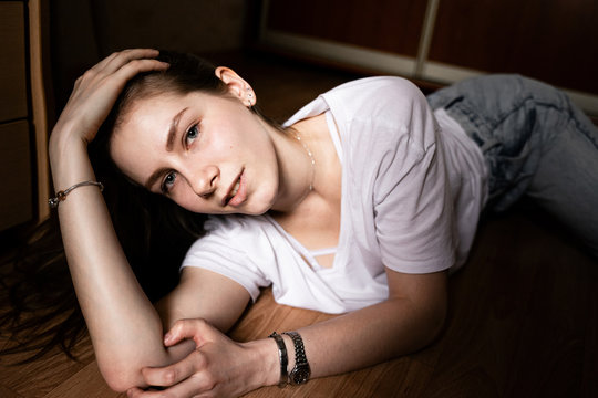 girl lying at home on the floor looking at the camera

