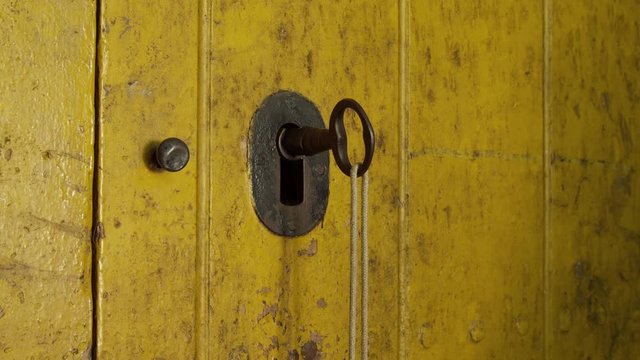 CU Man turning key in closed wooden door