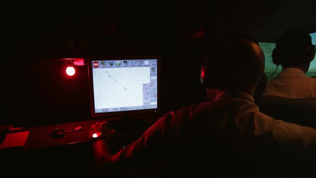 MS Rear view of instructor at control panel in professional flight simulator