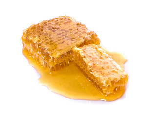 Honeycombs and sweet sticky honey puddle an isolated on white background