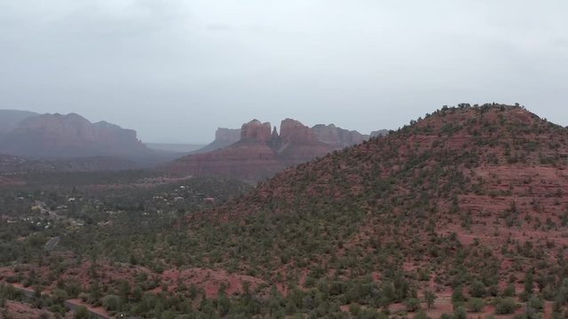 Car driving towards Cathedral Rock, Sedona Arizona, aerial rising reveal