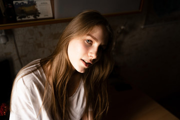 portrait of a girl sitting on a table looking at the camera