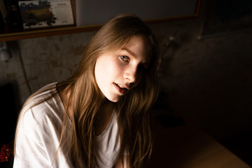 Fototapeta premium portrait of a girl sitting on a table looking at the camera