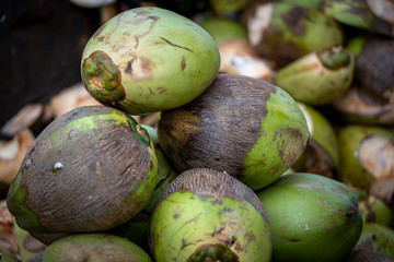 a closeup photo of coconuts stacked at a market
