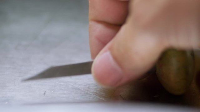 CU Hand of jeweler picking up graver tool