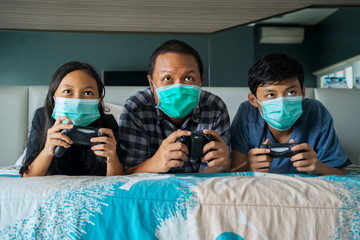 Father and his children playing video game on bed