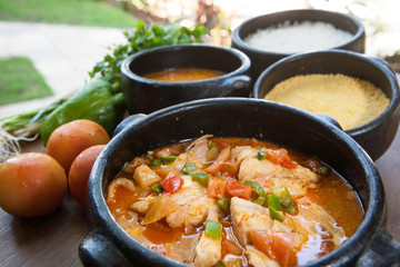 Seafood stew served in clay pots with vegetables on the side