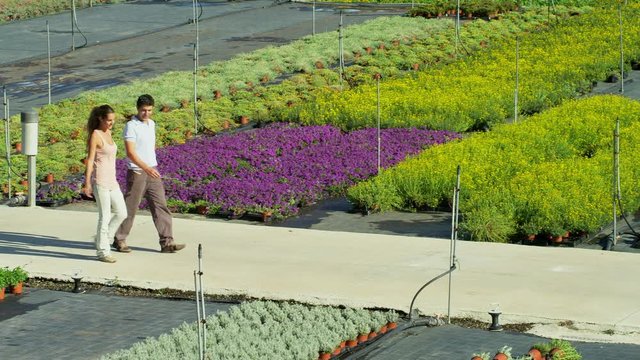WS TS Man and woman walking and talking in outdoor flower nursery