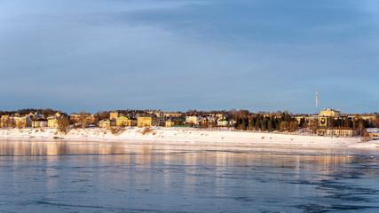 Panoramic view of a small provincial town on the banks of the river at sunset