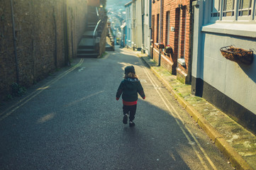 Preschooler running in street of small town