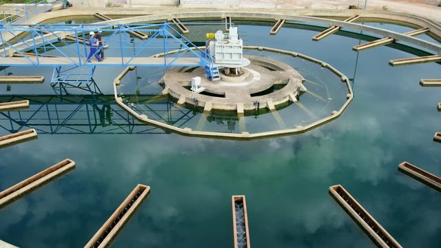 WS Workers taking water samples from clarifier basin in water treatment plant