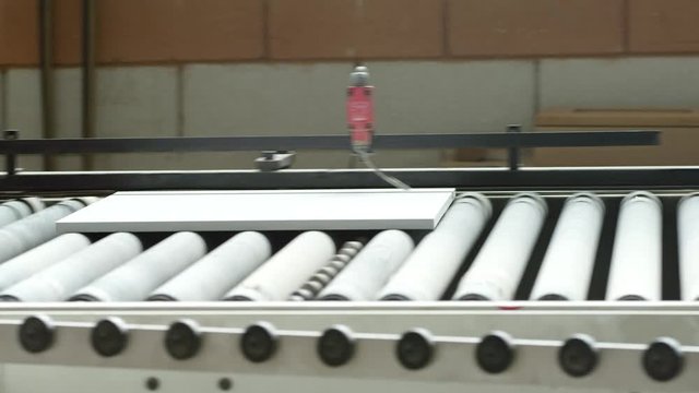 MS TS Panel of fiberboard moving through processing machine in furniture factory