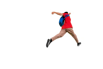 Fototapeta na wymiar Male student jumping with rucksack in studio