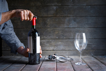 Male hands uncorking a bottle of  wine