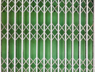 white steel folding door with green metal sheet background in full-frame shot, used for the background