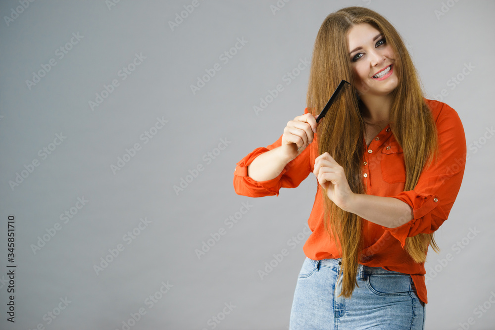 Poster Woman combing her brown hair