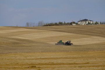 Obraz premium Agricultural tractor in a farm field preparing for planting