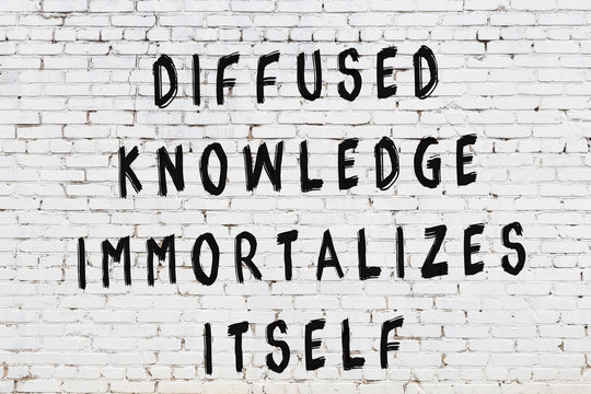 White brick wall with painted black inscription of wise quote