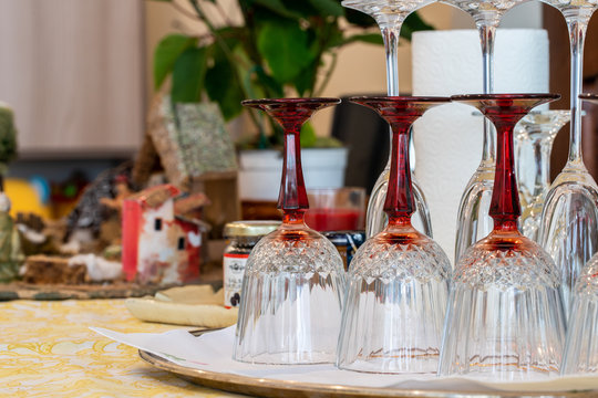 Preparations for the end of year dinner at home. Three glasses and three crystal glasses on a table against a background of some Christmas decorations and a plant.