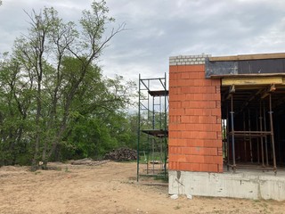 Close up of unfinished house in residential area. Modern architecture of construction brick house for comfortable stay of people.