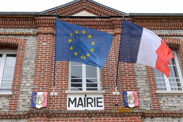 Facade d'une mairie avec drapeaux français et européen