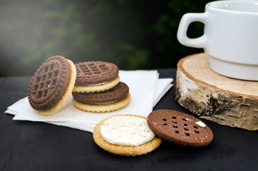 Delicious butter cream sandwich and cup of tea or coffee on the table. Close-up.