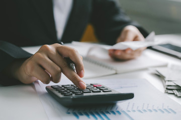 Closeup hands of businessman working on desk office with using a calculator to calculate the numbers, finance accounting concept