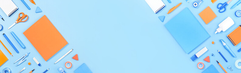 Assorted office and school white orange and blue stationery on background as corner border. Flat lay with copy space for back to school or education and craft concept. Blue monochrome long banner