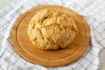 Homemade Irish Soda Bread on a round bamboo board, low angle view. Close-up.