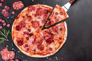 Pepperoni pizza with mozzarella cheese, salami, tomatoes, pepper and spices