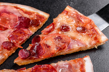 Pepperoni pizza with mozzarella cheese, salami, tomatoes, pepper and spices