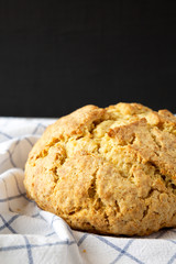 Homemade Irish Soda Bread on cloth, side view. Close-up.