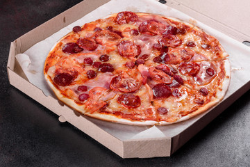 Pepperoni pizza with mozzarella cheese, salami, tomatoes, pepper and spices