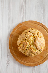 Homemade Irish Soda Bread on a bamboo board on a white wooden background, top view. Flat lay, overhead, from above. Copy space.