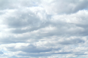 Clouds in the blue sky at sunset or dawn backlit by the sun. Place for text and design.