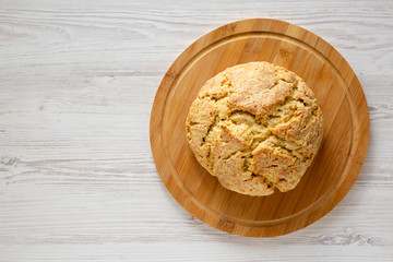 Homemade Irish Soda Bread on a bamboo board on a white wooden background, top view. Flat lay, overhead, from above. Copy space.