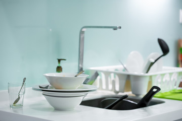 A mountain of dirty dishes in the kitchen sink. Mess in the house