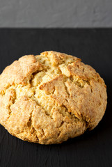 Homemade Irish Soda Bread on a black surface, side view. Close-up.