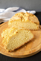 Fototapeta premium Homemade Irish Soda Bread on a bamboo board on a black background, low angle view.