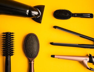 Professional hair dresser tools on yellow background with copy space, top view