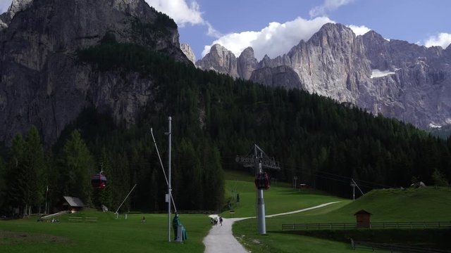 Cable cars pass each other in Dolomite valley in summer